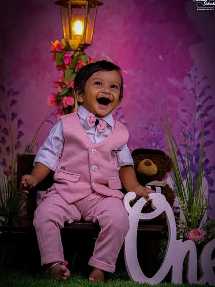 Sometimes, the best prop is a big, happy laugh. This shot in our pastel garden set, complete with a teddy bear and a "One" sign, shows how our simple, elegant backdrops let your baby's personality shine through.