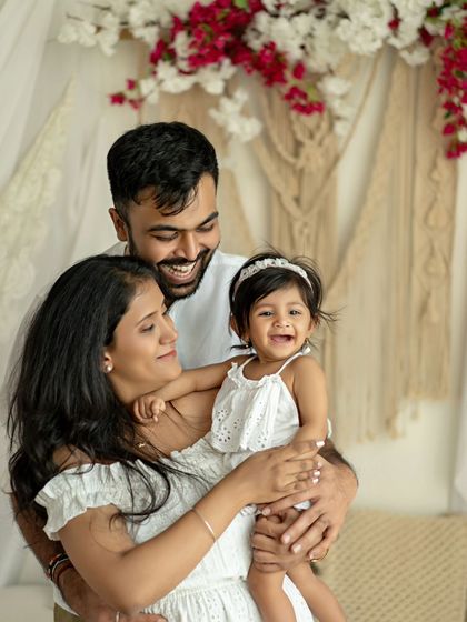 A family's happy smile. This portrait, with its bright and airy boho setup, is full of laughter and love.