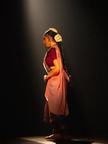 A quiet, contemplative moment under the spotlight before beginning a piece. This was captured during the 'Viśvambhara' performance.