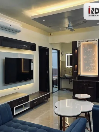 We seamlessly blend modern living with tradition. This living room features a sleek, contemporary TV unit and sofa, perfectly balanced with a custom designed, backlit temple unit, creating a peaceful and spiritual corner within the home.