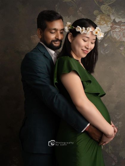 A gentle and serene couple's portrait against a painted floral backdrop, capturing a quiet moment of connection.