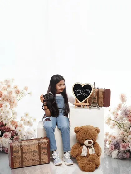 The future big sister is waiting for her travel buddy. This themed announcement shoot is a playful and imaginative way to share the family's exciting news.