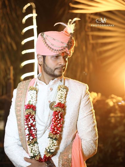 A handsome groom portrait taken at night. The lighting perfectly highlights the details of his wedding attire and his confident expression.