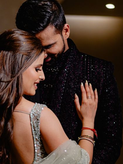 A quiet, intimate embrace. This photo highlights the couple's connection and the beautiful details of the bride's reception lehenga.