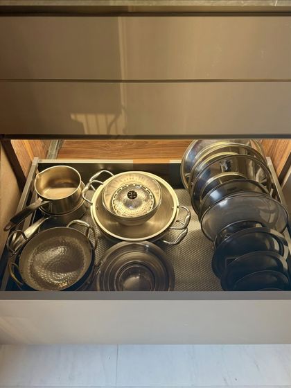 This deep drawer is organized with steel pots, pans, and lids. By nesting smaller items inside larger ones, we maximize storage and make everything accessible.