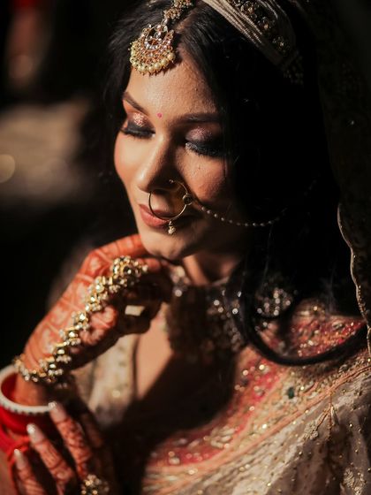 A close-up, low-light portrait of a bride, her eyes closed, highlighting her smokey eye makeup.