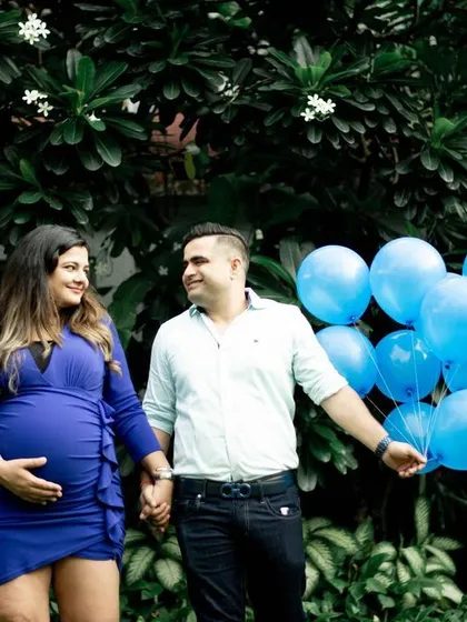 For the next part of their gender reveal session, the couple incorporated blue balloons. This is a classic and joyful way to announce you're having a boy, and the props add a playful element to the photos.