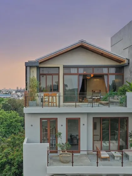 For the Magnolia Residence, a duplex penthouse in Bangalore, we designed an urban oasis. The structure features deep balconies and large windows to merge the indoor living spaces with the outdoors, creating a serene sanctuary that captures city views while maintaining a sense of tranquility.