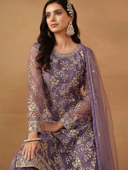 This purple net salwar kameez with sharara pants is a festive dream. The all-over sequence and thread work make it sparkle from every angle.