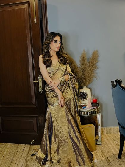 A full-length shot of the golden sangeet saree I designed. The pre-draped style makes it comfortable and easy to dance in all night.
