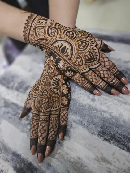 A beautiful example of a symmetrical design for both hands, featuring a central lotus motif surrounded by intricate net and paisley patterns.