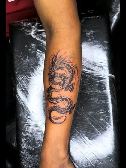 Another view of the completed dragon cover-up tattoo, showcasing the detail in the scales and the fluid motion of the design from a different angle.