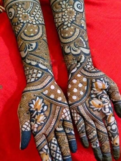 A vibrant and colorful bridal design featuring white henna accents on the lotus motifs, adding a modern and unique touch to the traditional patterns.