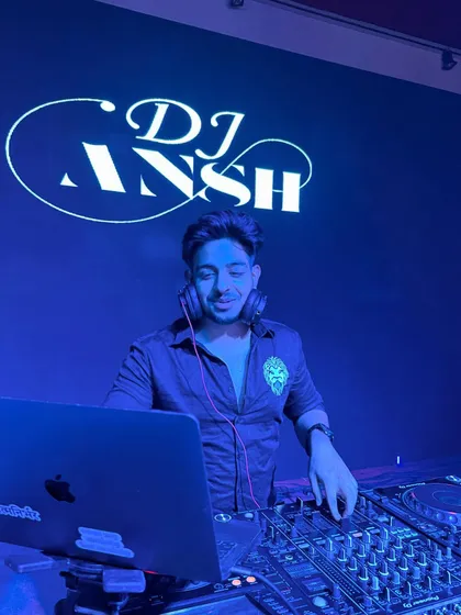 Focused and in the zone with my logo lighting up the background. This is me at my console, ready to take control of the night's energy and deliver a seamless DJ set for any private party or club night.