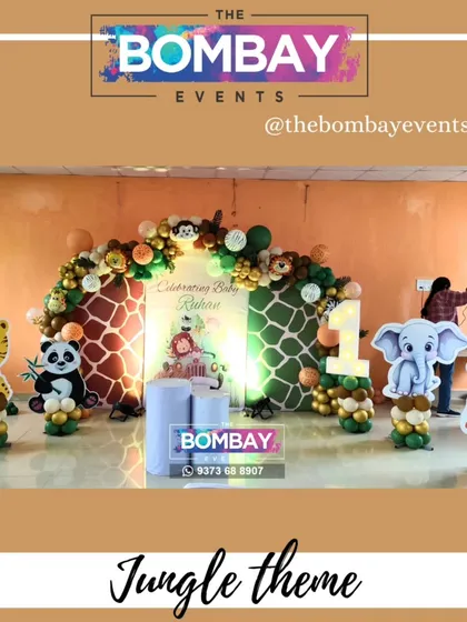 A full view of a jungle-themed birthday setup featuring a triple backdrop with giraffe prints. The scene is completed with character cutouts of a tiger, panda, elephant, and giraffe.