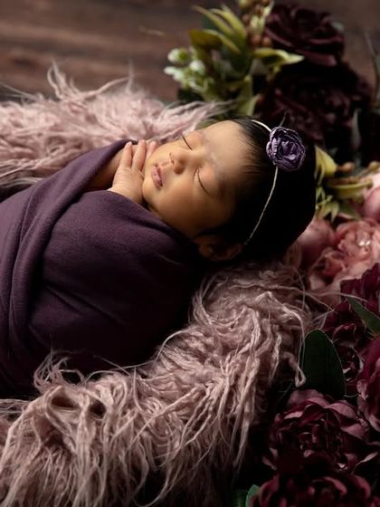 A side view of the floral basket setup, focusing on the baby's peaceful expression as they sleep.