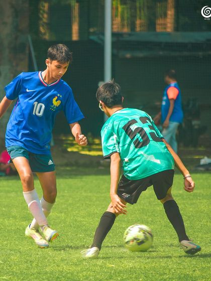 Two older players challenge for the ball, showing the progression of skill in our academy.