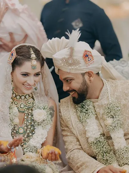 Aditya and Megha share a look during their wedding ceremony. This candid shot captures the quiet communication and deep bond between the couple amidst the traditional rituals.
