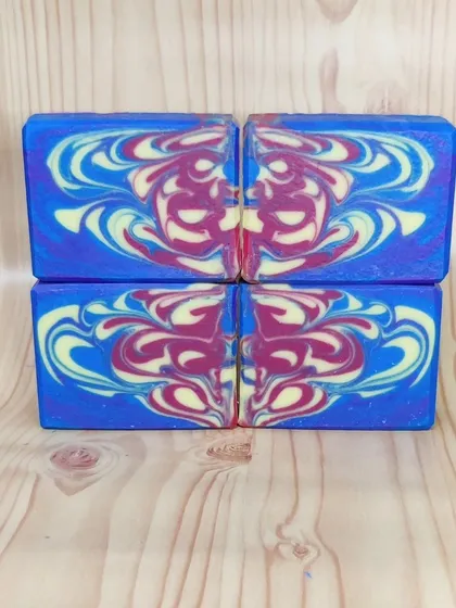 A bookmatched pair of my drop swirl soaps, showing the symmetrical design created by the pour. Each half of the loaf is a mirror image of the other.