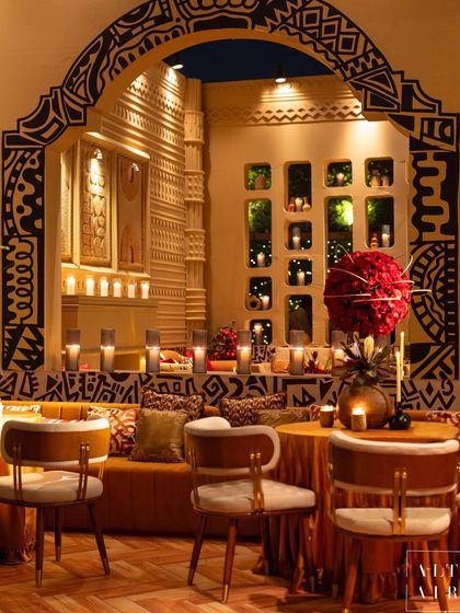 A seating nook from the 'Mid-Century Mod' event, showcasing hand-painted tribal patterns on the archway and textured fabrics. The monotone color palette was enriched with an abundance of textures and artisanal details.