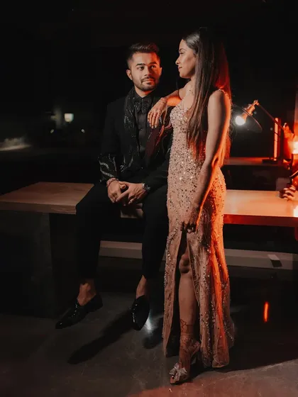 A stylish portrait of the couple at their cocktail party, with dramatic red backlighting creating a cinematic feel.