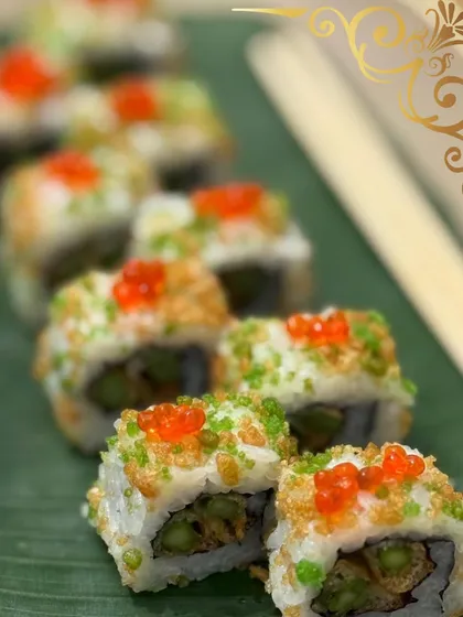 My sushi rolls are crafted to be a feast for the eyes and the palate. This roll, topped with tempura crunch and bright tobiko, showcases my commitment to texture, color, and fresh ingredients.