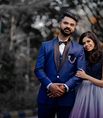 A classic portrait from an engagement ceremony. The couple looks sharp and elegant in their formal blue attire.