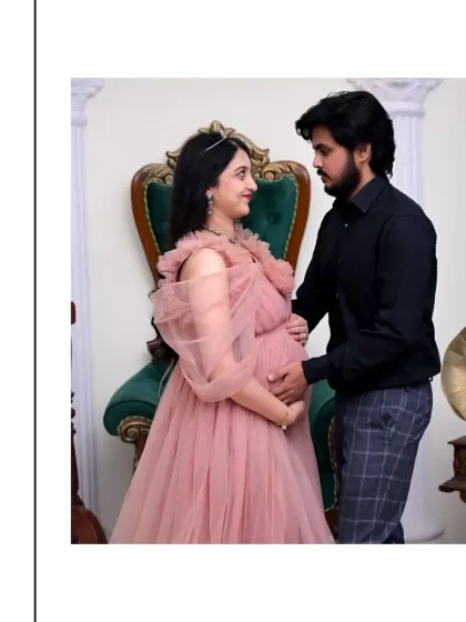 An intimate look between a couple in our royal setting. The mom-to-be is seated on the throne chair while her partner stands beside her, creating a portrait that is both regal and deeply personal.