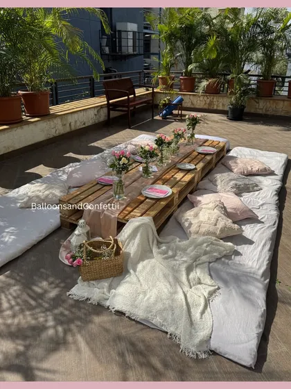 The full picnic setup, showing the arrangement of mattresses and cushions around the table, creating a cozy and inviting space for guests.