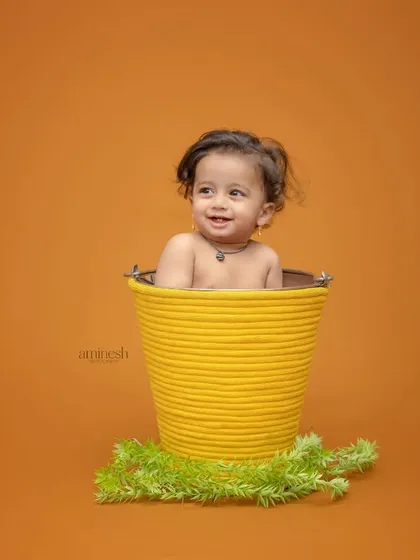 Peek-a-boo! A fun shot of a baby peeking out of a bright yellow bucket. I use simple props like these to encourage play and capture genuine smiles.