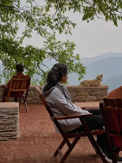 Visitors enjoying the serene valley view from the Sargakhet Handicraft Centre in Uttarakhand. This adaptive reuse project revived a British-era structure, turning it into a space that supports local artisans and offers a moment of quiet reflection for travelers.