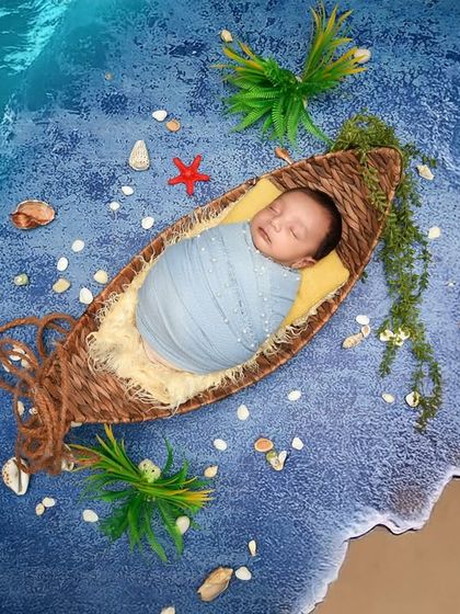 An overhead view of the beach theme, showing the baby "floating" in a boat on the water. These artistic shots are created safely in the studio.