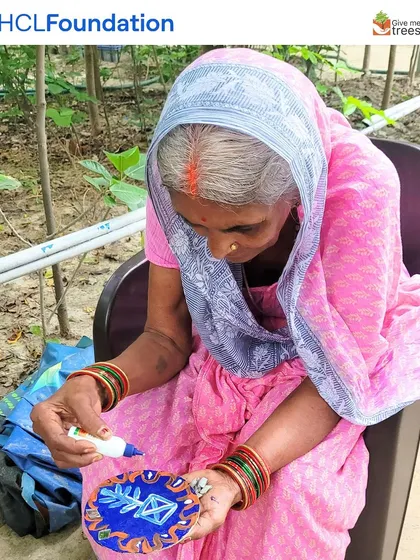 An elderly woman from the community participating in the art workshop. Our programs are inclusive, bringing together people of all ages to learn and create.