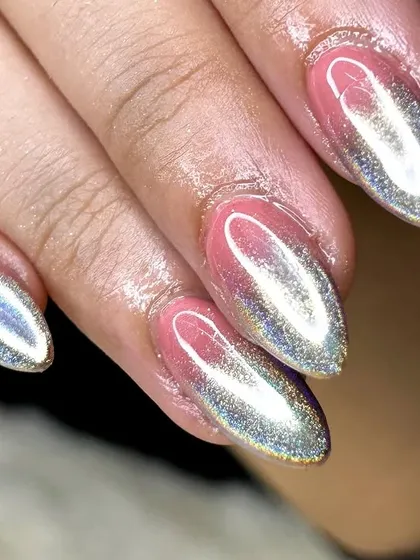 An extreme close-up showcasing the intense holographic effect of the chrome powder on these almond nails.