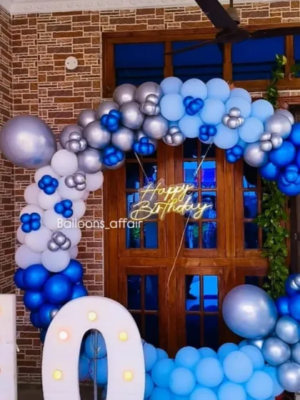 A full view of the blue and silver circular balloon arch against a wooden door, perfect for a home celebration.