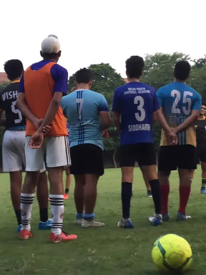 Players listening to their coach. Discipline and respect are core values we teach at the academy.