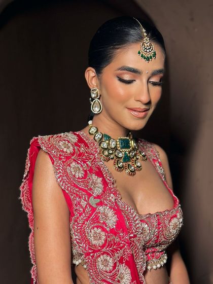 A close-up capturing the soft, glowing makeup on this bride. The eyeshadow is blended to perfection, and the skin has a luminous quality that looks beautiful in the warm, ambient light.