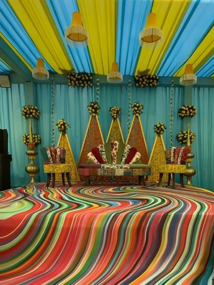 For a client who wanted something truly unique, I designed this colorful and psychedelic Mehendi stage. The decor uses a multi-colored swirling floor pattern and a backdrop of triangular floral panels.