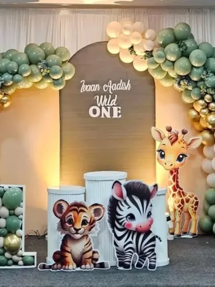 A "Wild One" first birthday party comes to life with a full jungle safari theme. We designed this complete setup featuring a custom backdrop, an organic balloon arch in earthy tones, and adorable animal cut-outs.