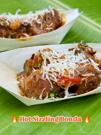 A serving of my Hot Sizzling Bonda, topped with grated cheese. The combination of the spicy sauce, soft bonda, and melted cheese creates a perfect harmony of flavours and textures.