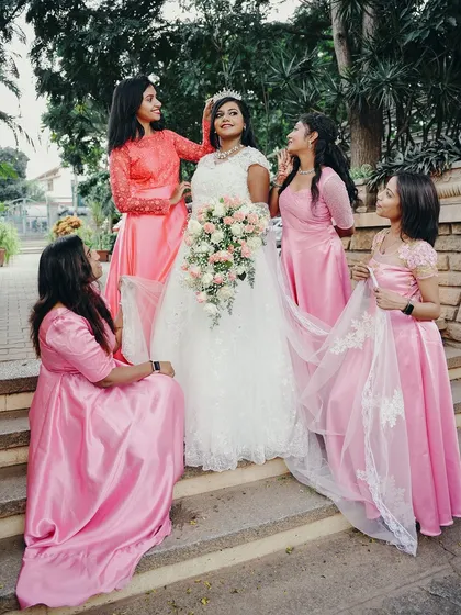 A candid moment of admiration between the bride, wearing her tiara, and her bridesmaids.