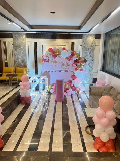 A wider view of the 20th birthday celebration, showing balloon pillars that match the main backdrop.