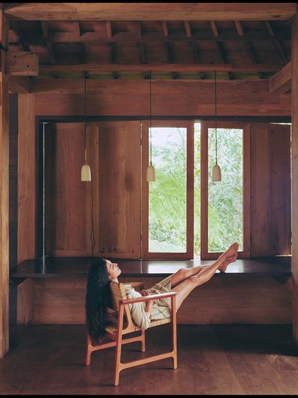 A moment of pure relaxation. The styling and pose are effortless, reflecting the comfortable elegance of the AMPM resort wear collection.