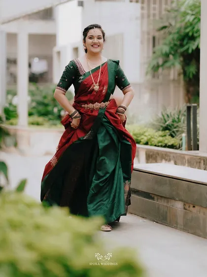 The bride's happiness is infectious in this shot, as she walks forward in her beautiful red and green half saree.