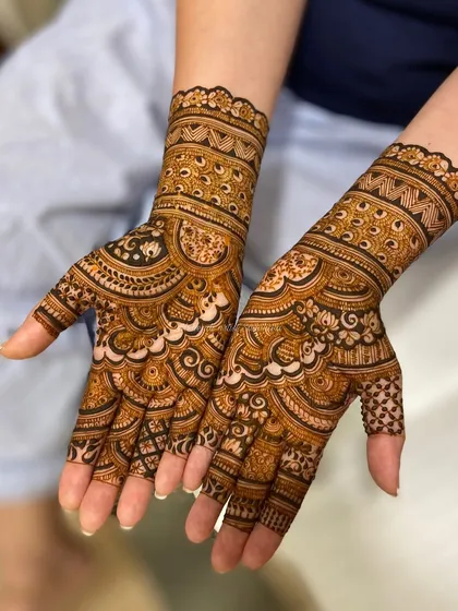 A gorgeous bridal design with scalloped edges and dense, flowing patterns that cover the hands beautifully.