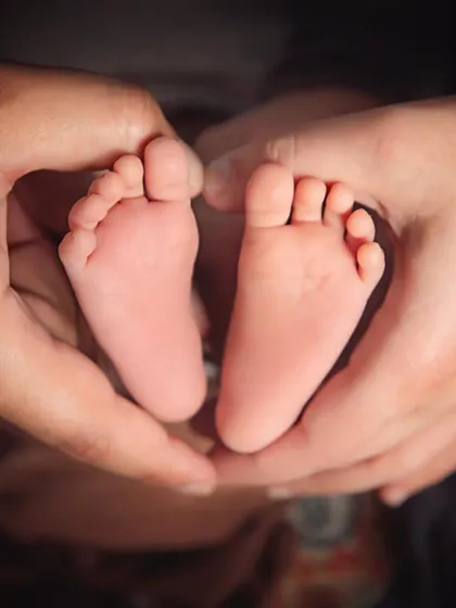 Sometimes it's the tiniest details that hold the biggest memories. I love capturing close-ups of your baby's little feet held safely in your hands, a beautiful symbol of your new family.