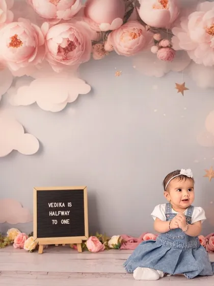A sweet moment during her floral-themed sitter session. The letter board announces that she is "halfway to one".