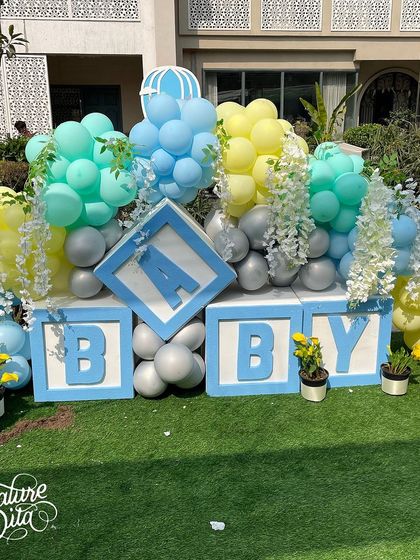 A fun 'BABY' block installation decorated with balloons and flowers for the baby shower.