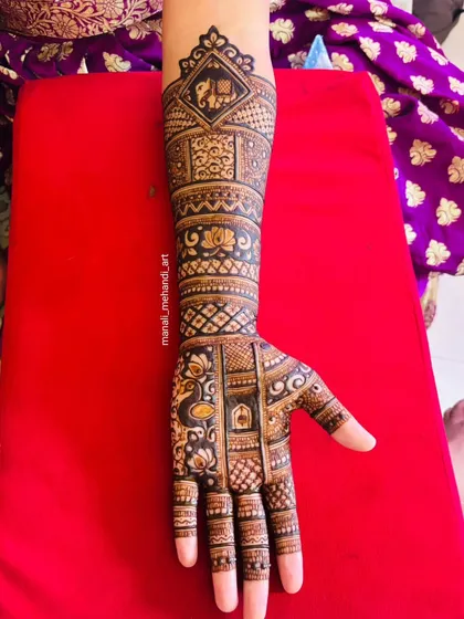 A single-hand view of a bridal design, showing a mix of popular motifs. You can see an elephant in a checkered box at the top, with lotus and peacock figures woven into the pattern below.