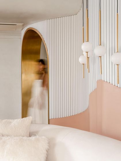 A motion-blurred shot capturing the ethereal feeling of moving through the brass-lined archways of the "Marshmallow" penthouse.